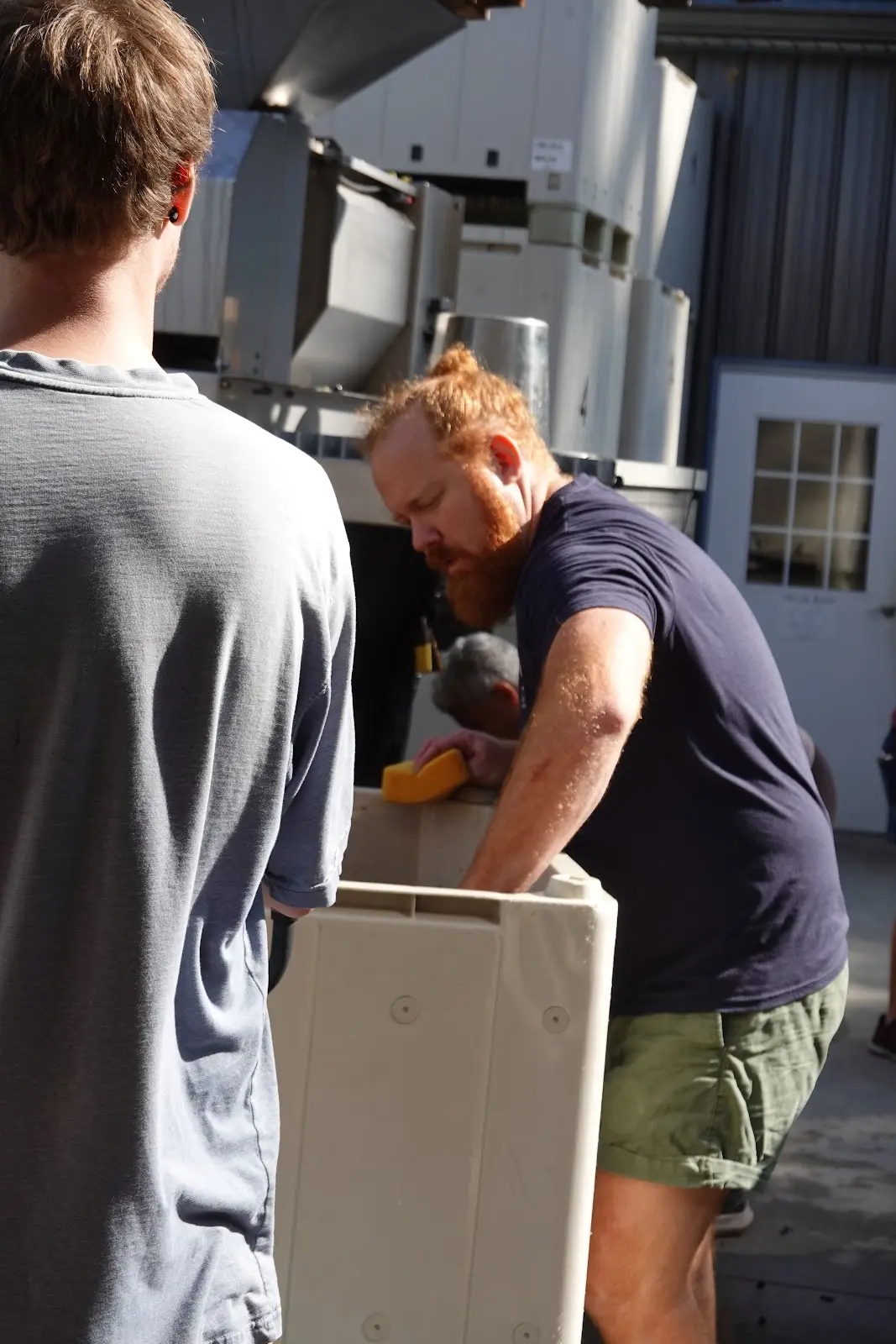 Two Cellar Beast team members loading the press during harvest